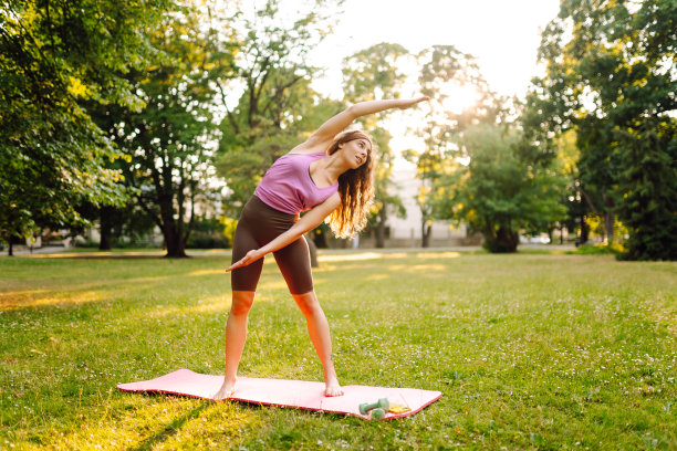 一个美女在公园里做瑜伽的画像。积极的生活方式。健身,运动。图片下载