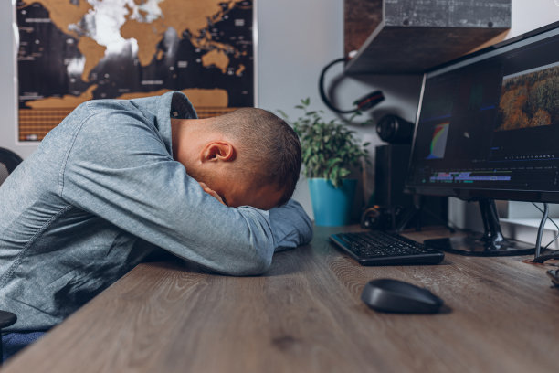疲惫的商人睡在家里办公室的桌子旁图片下载