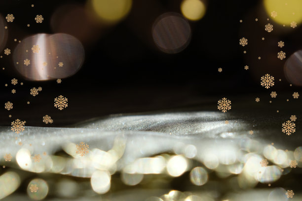 圣诞的金色雪花和散景在黑色的夜晚背景上，明亮的辉光散景。闪闪发光的光。本空间图片下载