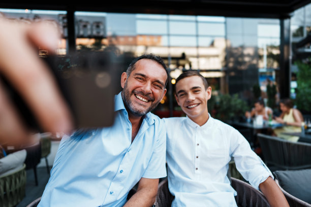 父子俩在现代咖啡吧或餐厅图片下载