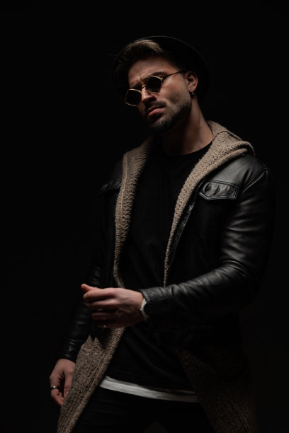 戴着帽子和太阳镜的自信男人以时尚的方式挽着手臂图片下载