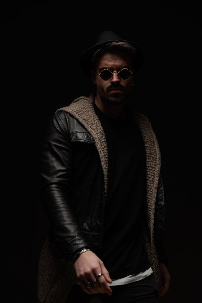 满脸胡须，戴着帽子和眼镜，穿着皮夹克的自信男子图片下载