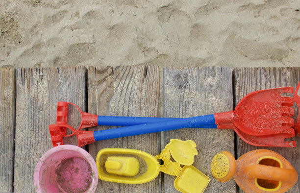 孩子们的海滩玩具被遗弃在木板路上图片下载