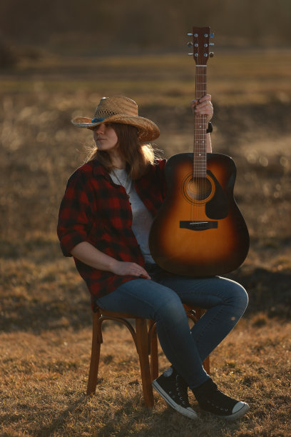 牛仔女郎在日落时弹吉他图片下载