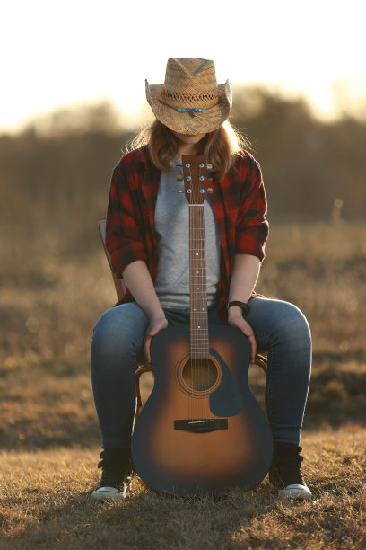 牛仔女郎在日落时弹吉他图片下载