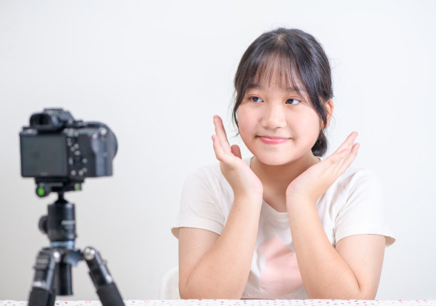 美少女博主概念，亚洲少女在直播中看着镜头挥手问好图片下载