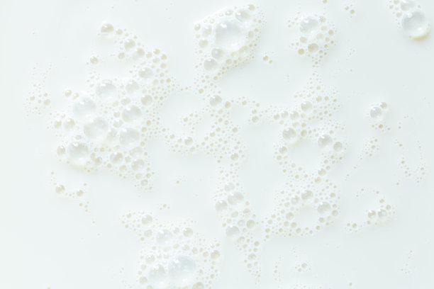 宏观的牛奶质地，白色的牛奶表面和气泡和涟漪从鸟瞰图片下载