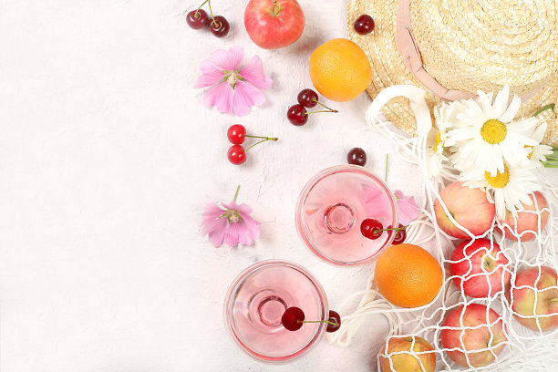 明亮背景的夏季时尚横幅。草帽，生态袋里的水果，清爽的酒精饮料和阳光明媚的桌子上的洋甘菊。度假旅游理念，户外露营和节日聚会。图片下载