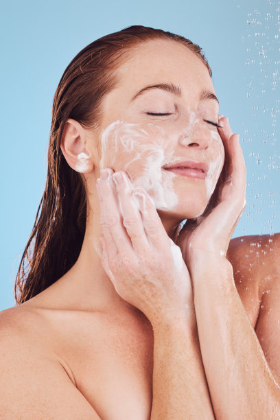 女人，洁面和泡沫与美容，淋浴和卫生与面部隔离在蓝色背景。女模特，可持续性和水滴与肥皂面膜，皮肤病学和护肤工作室图片下载