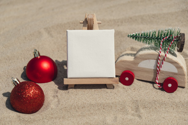空白的白纸笔记框架与复制空间为您的文字或设计显示在沙滩上。圣诞球车用圣诞树装饰新年。暑假和假期商务旅行的概念。模板模拟销售促销广告图片下载