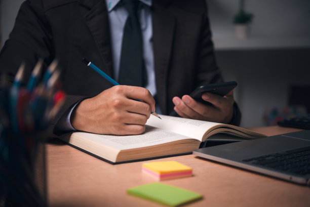 通过使用笔记本电脑和在工作场所写笔记本来学习在线课程，教育发展或知识改进的概念。图片下载