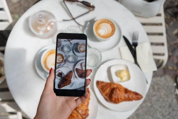 一名女子用智能手机在咖啡馆拍早餐图片下载