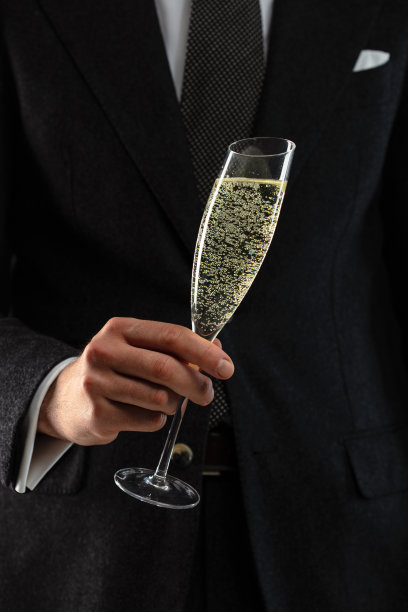 商人拿着一杯神奇的发光香槟。图片下载