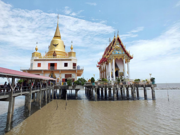 一张码头的照片，上面有一座建筑和一个金色的圆顶，有两座建筑矗立在水面上。图片下载