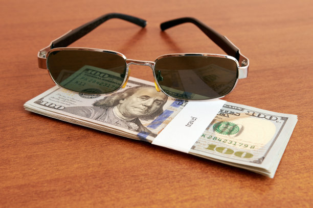 上面写着度假和太阳镜的一捆美元。度假钱的概念。图片下载