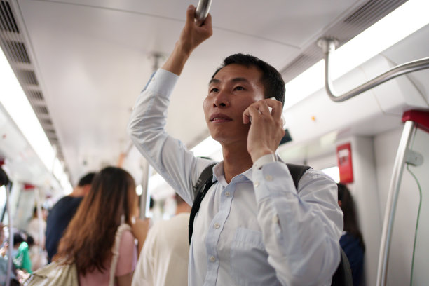 商人在地铁车厢里接电话图片下载