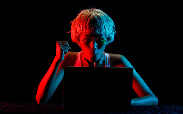 金发女子在笔记本电脑交易加密货币股票盈利，玩在线游戏的乐趣图片下载