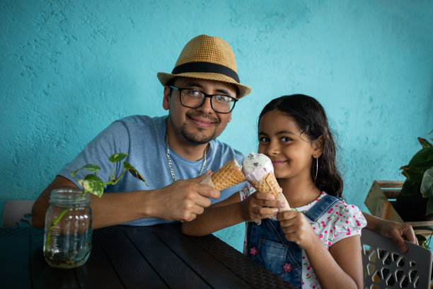 爸爸和孩子对着镜头微笑着吃冰淇淋的照片图片下载