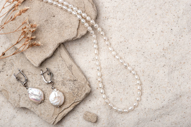 美丽的珍珠首饰在白色的沙滩上。图片下载
