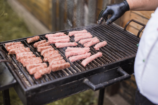 厨师在烤架上整理肉图片下载