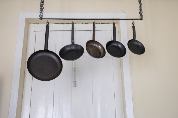 旧房子的架子上挂着金属煎锅图片下载