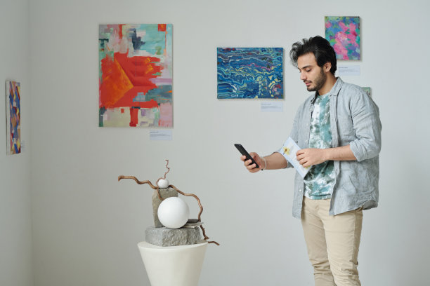 男子在美术馆拍摄雕塑作品图片下载