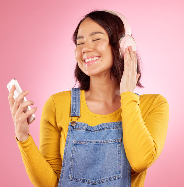 女人，耳机和手机在演播室，快乐或思考音乐，记忆或放松粉红色的背景。z世代女孩，日本学生和微笑的想法，音频应用程序或收听流媒体订阅图片下载