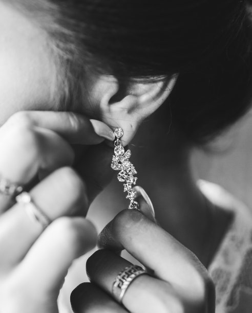 新娘戴着珠宝。白色人造钻石耳环。优雅的风格。结婚的那一天。图片下载