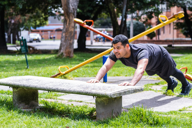 在附近的公园里，一名哥伦比亚男子在长凳上做俯卧撑图片下载