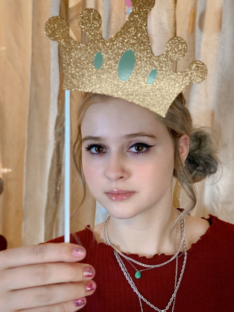 可爱的十几岁的女孩在一个自制的照相亭聚会上玩打扮。图片下载