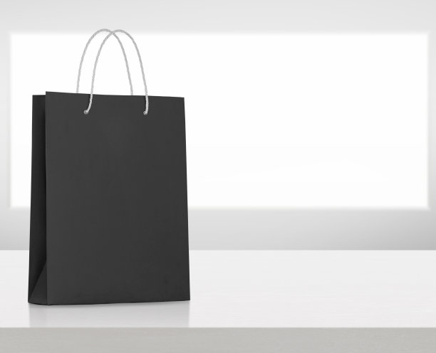 白色木桌上的黑色纸袋图片下载