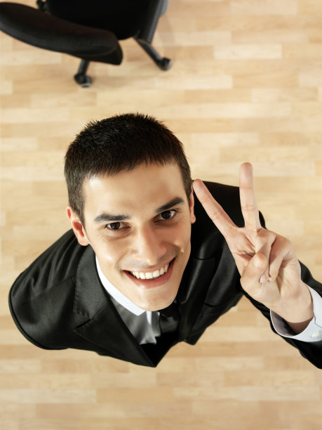 年轻的商人在做胜利的手势图片下载