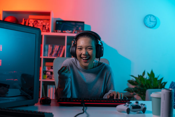 快乐的年轻亚洲女性一边玩电子游戏一边欢呼图片下载