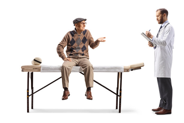 一位老人坐在理疗床前和医生交谈图片下载