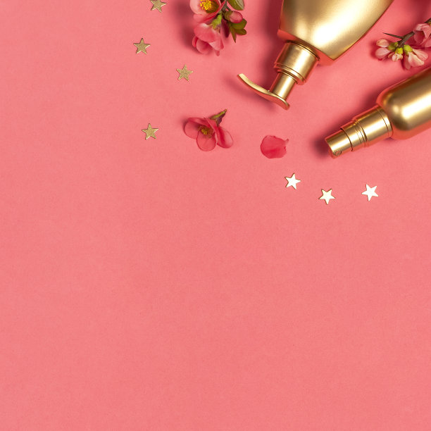 化妆品品牌的概念。化妆品，春天的粉色花朵，粉红色背景上的金色星星。化妆品模拟金瓶子。平面俯视图拷贝空间。化妆品，美容背景图片下载