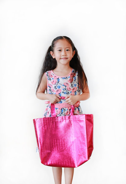 亚洲小女孩拿着充满活力的粉红色回收袋，孤立在白色背景上。再利用以减少全球变暖的概念。图片下载