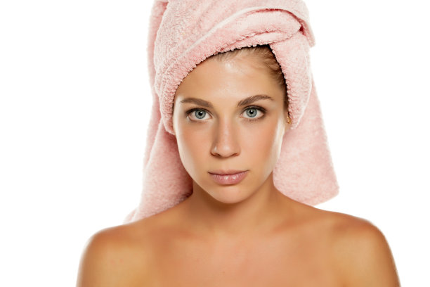 一个年轻漂亮的蓝眼睛女人用毛巾蒙头摆姿势图片下载