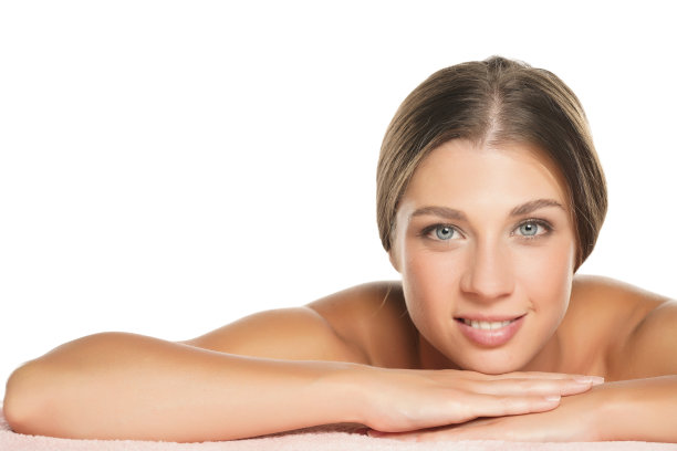 一个年轻的微笑的美丽的女人躺在白色的肖像图片下载
