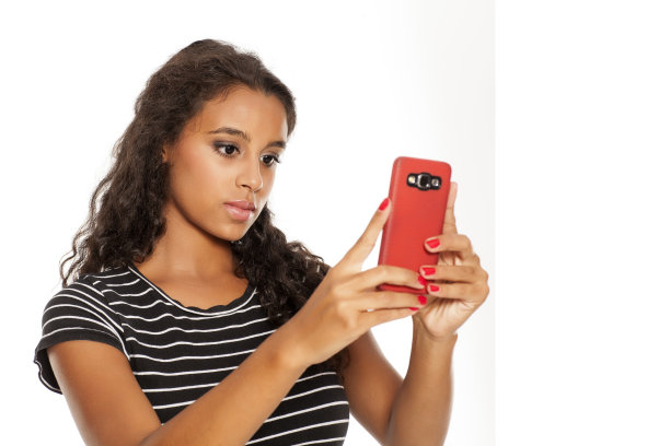 年轻快乐的黑皮肤女孩正在用她的智能手机拍照图片下载