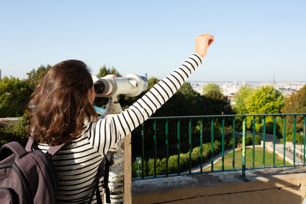 在她身后，一个年轻的女人举着胳膊从望远镜里看过去图片下载