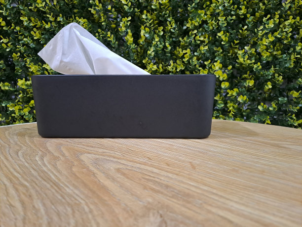 桌子上的纸巾盒，背景是树叶图片下载