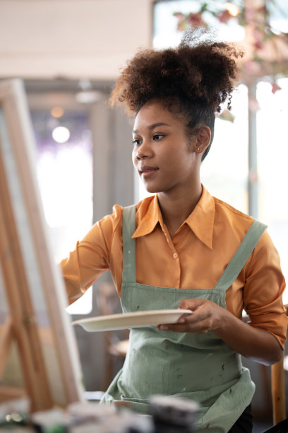 年轻的艺术家美丽的美国非洲人在她的绘画工作室工作图片下载