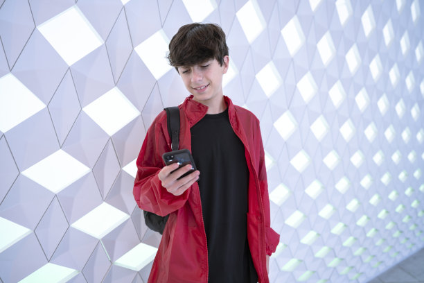 一个像数字游民一样的青少年在奥斯陆歌剧院里使用他的智能手机。这个男孩似乎在宇宙飞船上与人交流图片下载