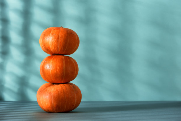 堆装饰南瓜与阴影在蓝色柔和的背景。侧视图，选择性聚焦。感恩节和万圣节的概念。图片下载
