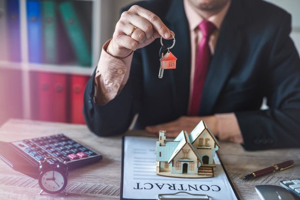 人们根据房屋的建筑模型签订合同，手里拿着房子的钥匙图片下载