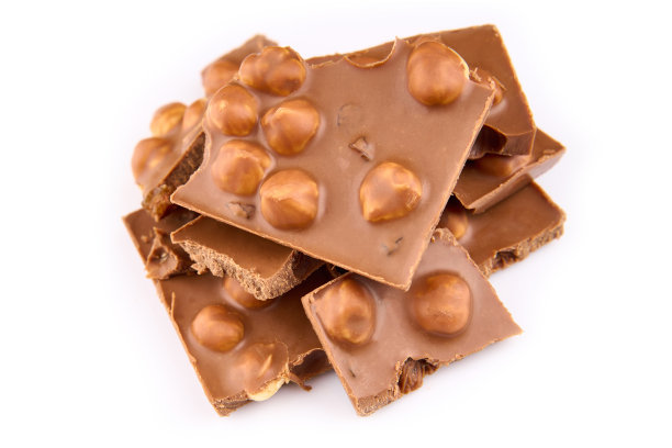 巧克力棒的微距照片。白色背景上的碎片。牛奶巧克力块被隔离在白色背景上。图片下载