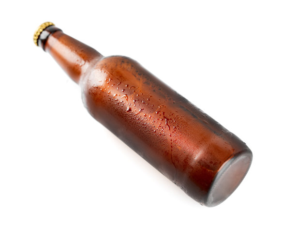 工作室照片孤立瓶啤酒在白色背景。一瓶冰凉的啤酒，上面有凝结水滴。啤酒瓶上孤立着白色的水滴图片下载