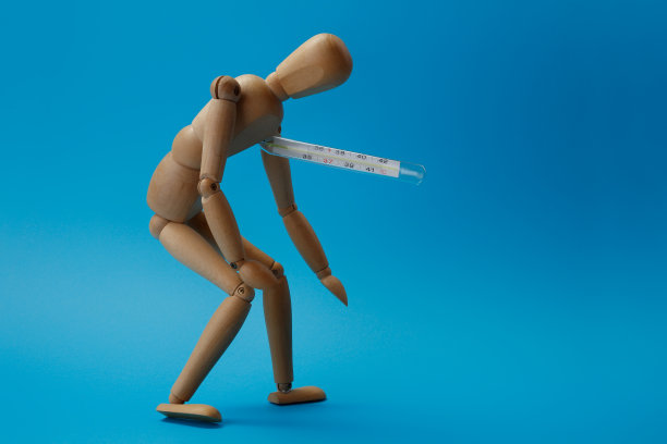 木制的人体模型摆出疲惫的姿势，拿着温度计、度量计。图片下载