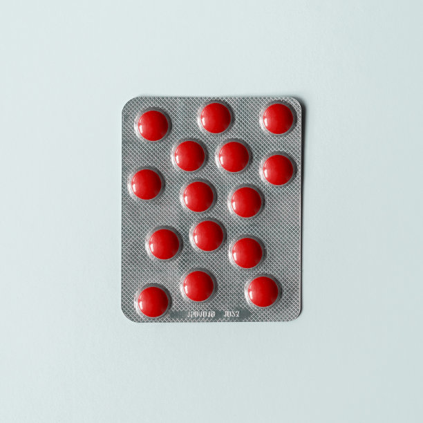 药品的创造性概念化。水泡与红色药丸在混乱的顺序在蓝色的背景。图片下载