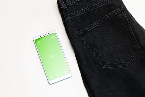 平板购物与智能手机，色度键绿色屏幕，牛仔裤布在白色背景。电子商务、应用程序、网上购物。现代技术。水平面。牛仔布图片下载